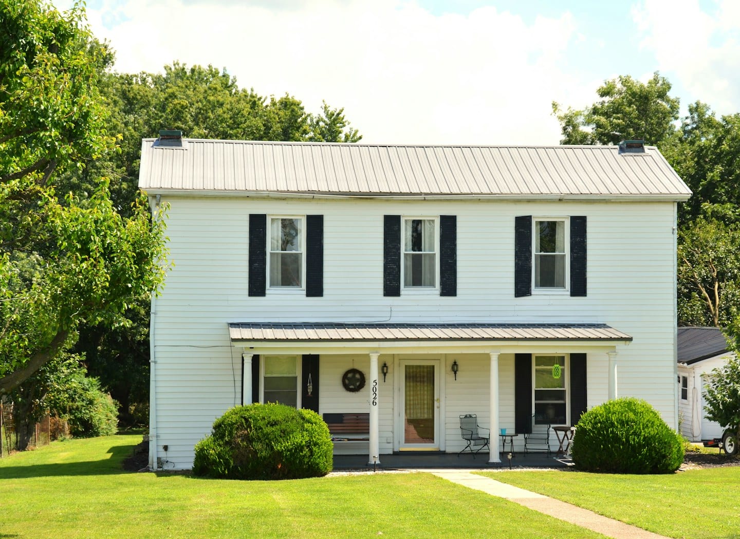 A white house with dark shutters; illustrative residential photography.